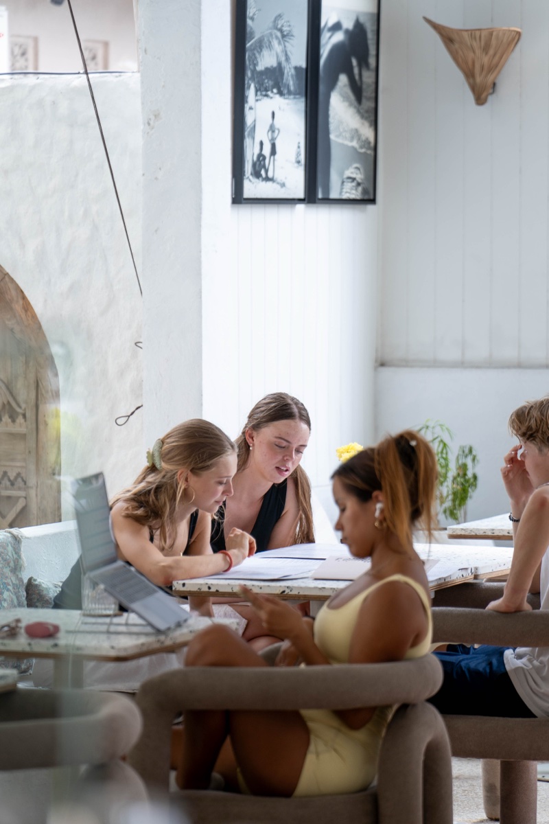 Guests co-working at a table inside Mowie's